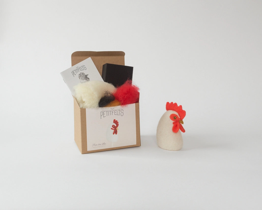 A box with bits of wool  sticking out and a finished felt hen sitting next to it.